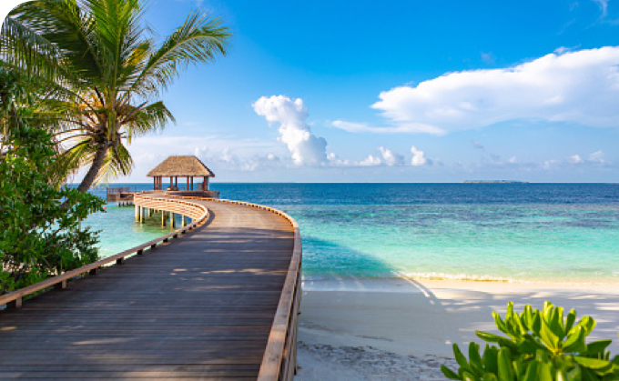 Vacation photo of a boardwalk leading to a dock on a calm beach.