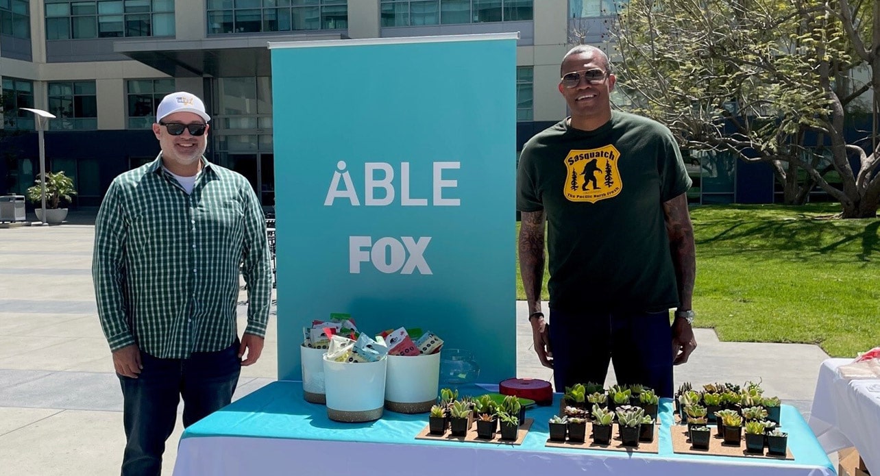 Two FOX employees standing at an ABLE event