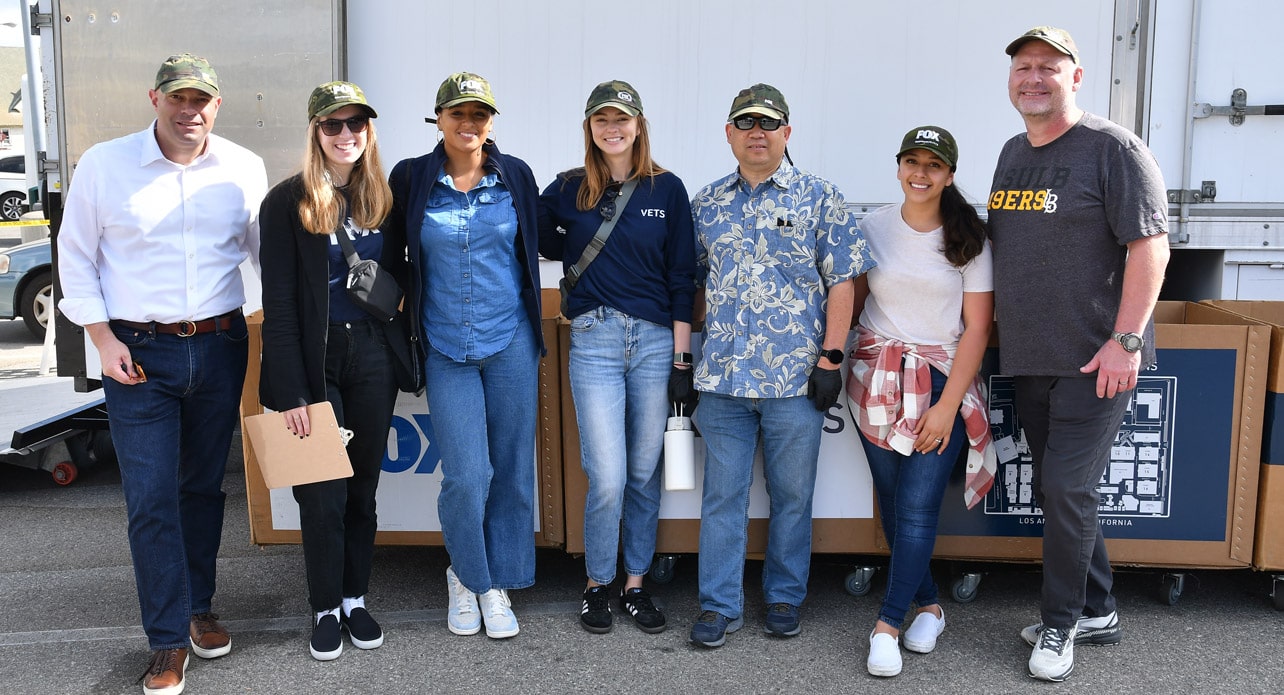 Eight FOX employees posing together at a VETS event